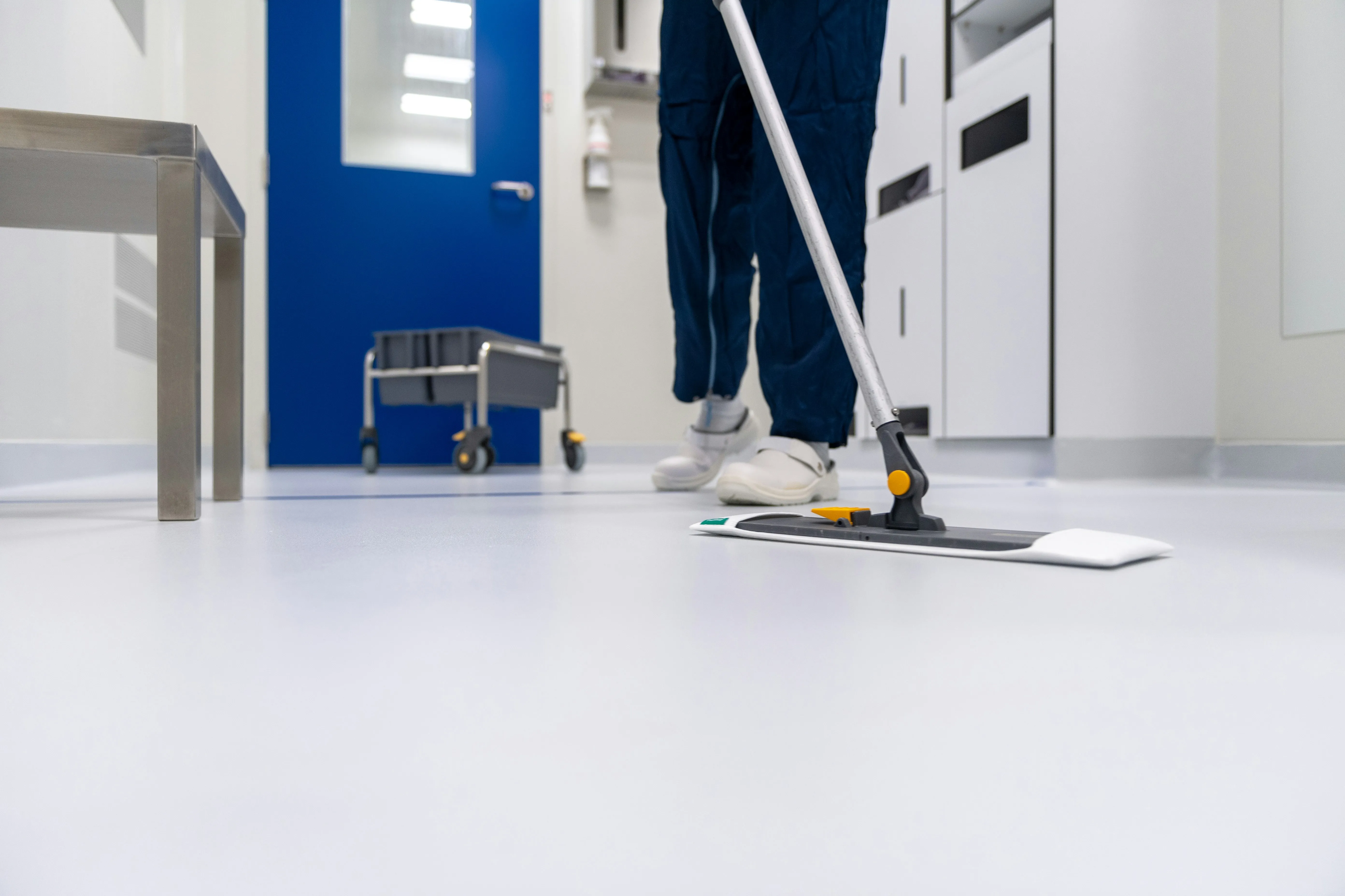 Noble Cleaning Solutions crew member mopping a commercial facility floor